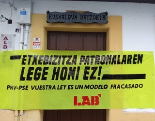 LABek Premiazko Neurrien legea salatzeko pankartak jarri ditu Arrasateko EAJ eta PSEren egoitzetan