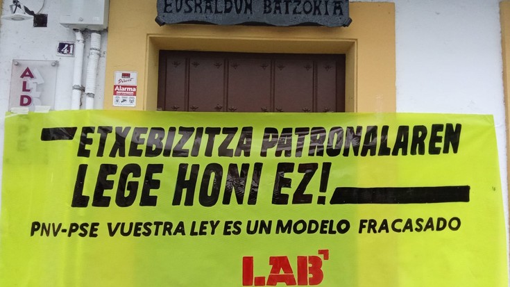 LABek Premiazko Neurrien legea salatzeko pankartak jarri ditu Arrasateko EAJ eta PSEren egoitzetan