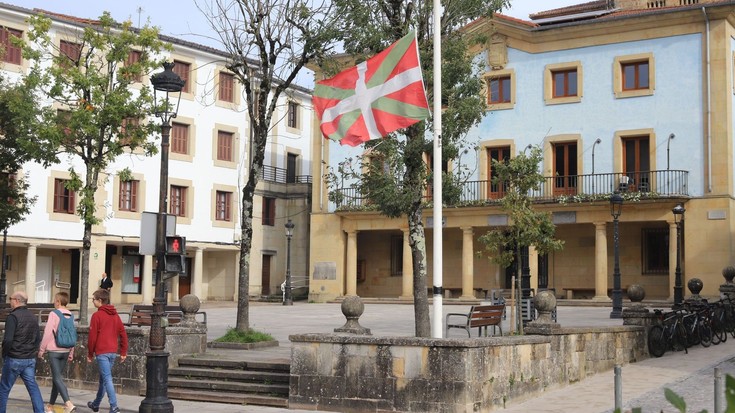 Hiru dolu-egun eta Mendizaleen plazako ikurrina haga erdira